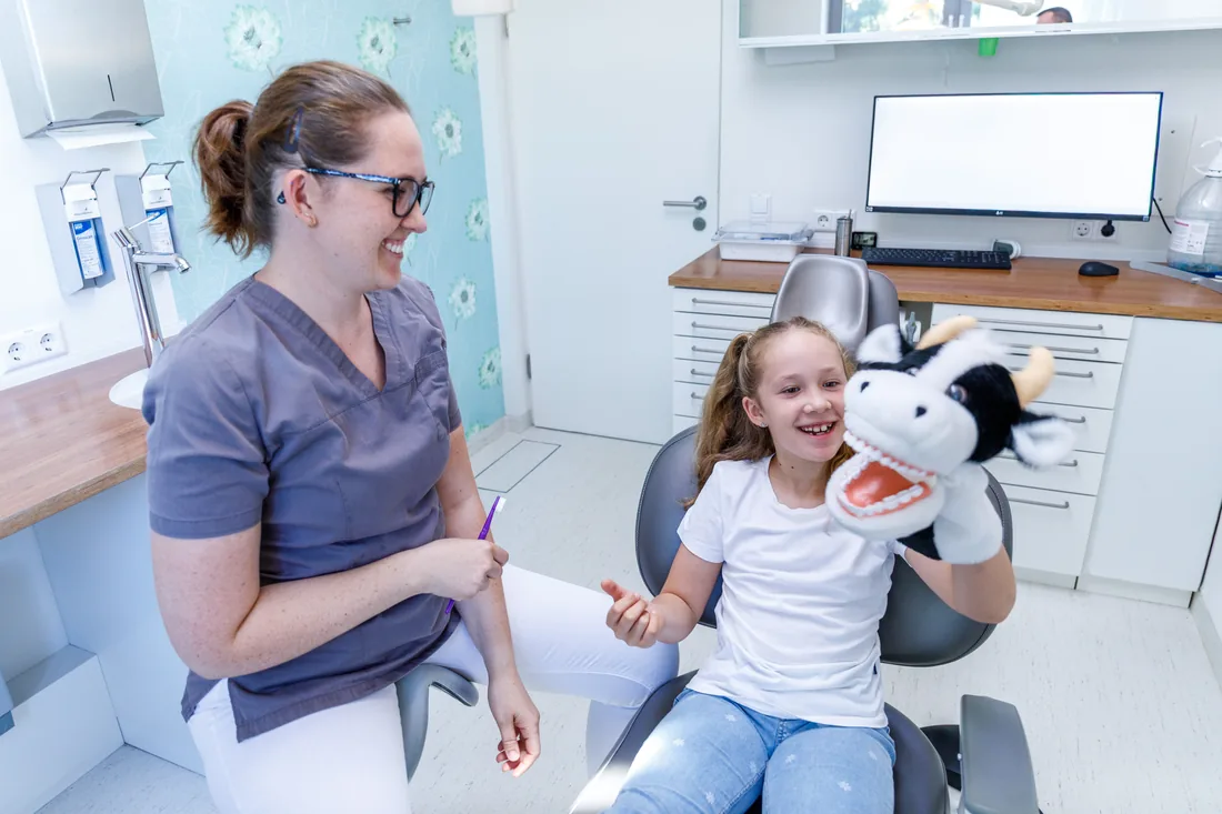 Kinderzahnheilkunde in Bühl – ein Kind spielt mit der Kuh-Handpuppe im Behandlungszimmer